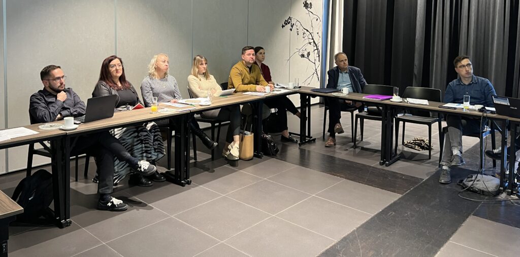 Jedno ze spotkań. Uczestnicy siedzą przy stole i rozmawiają